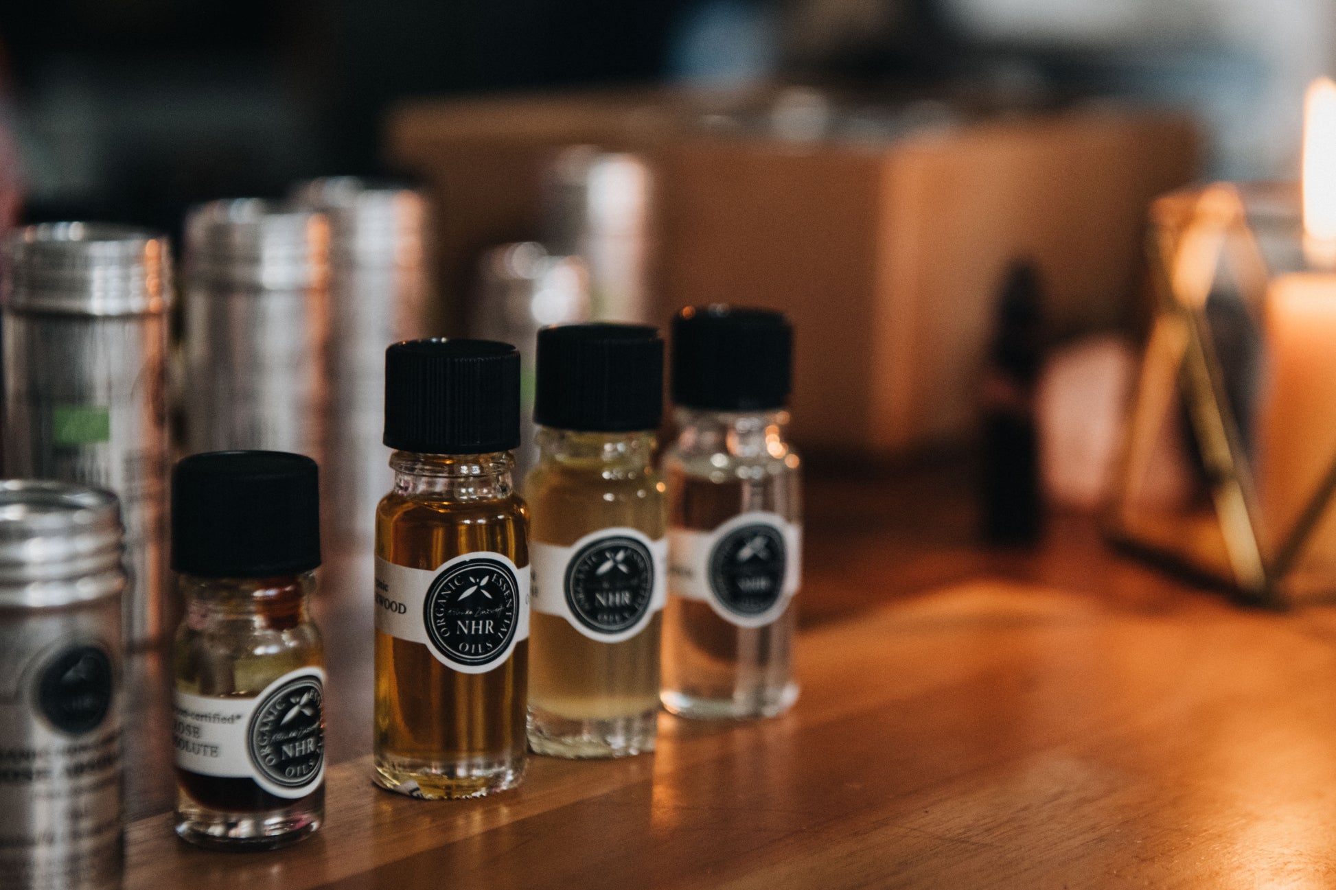 Small bottles with black caps and labels on a wooden surface
