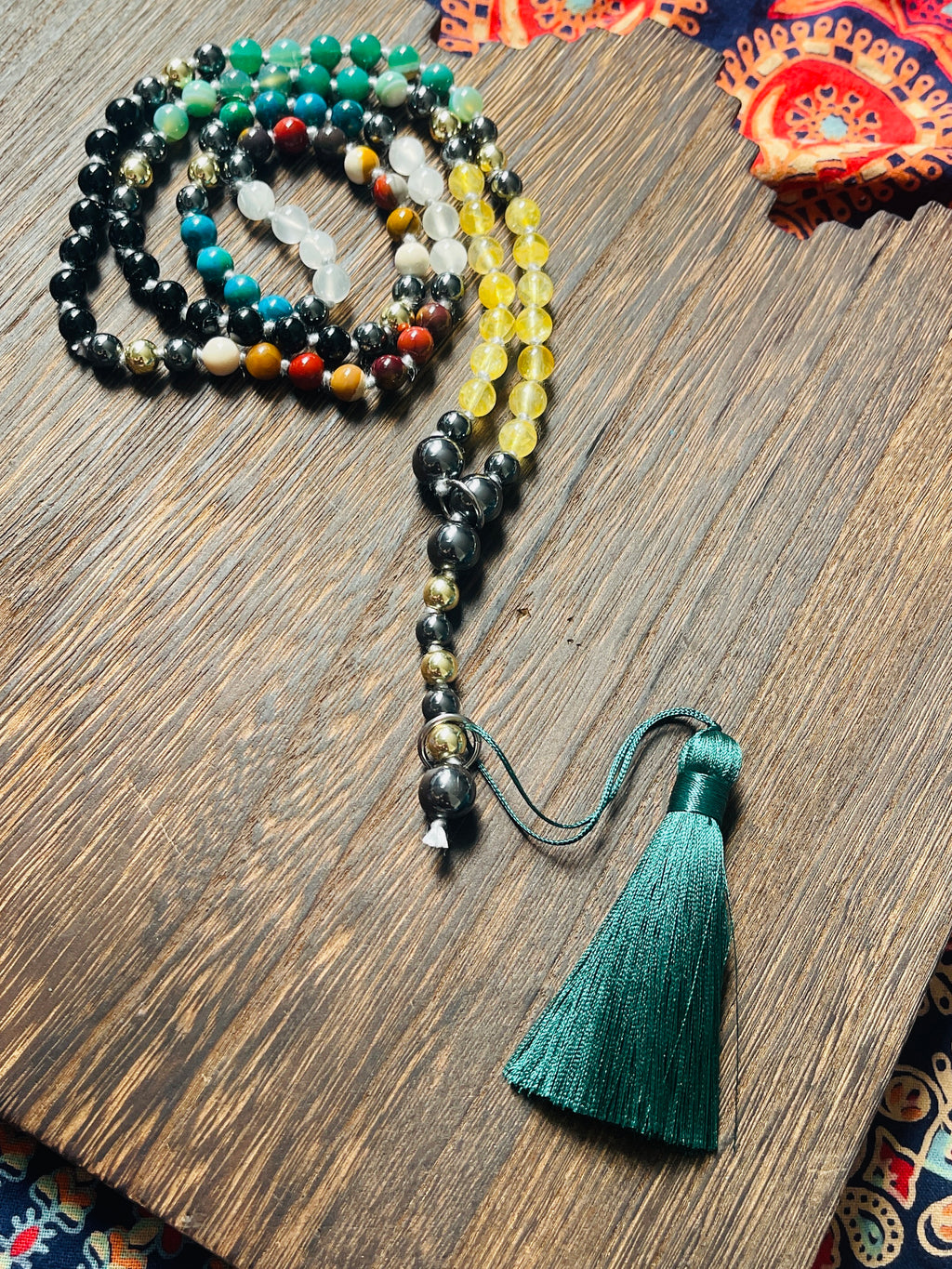 Path of Prosperity crystal mala shown with its removable Metatron's Cube talisman and emerald green tassel.
