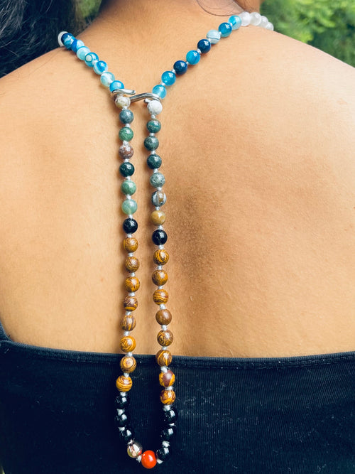 Back view of a handcrafted bespoke crystal mala by Starlight Rituals, showing the natural drape, individually hand-knotted gemstones and silver-toned soul cord.