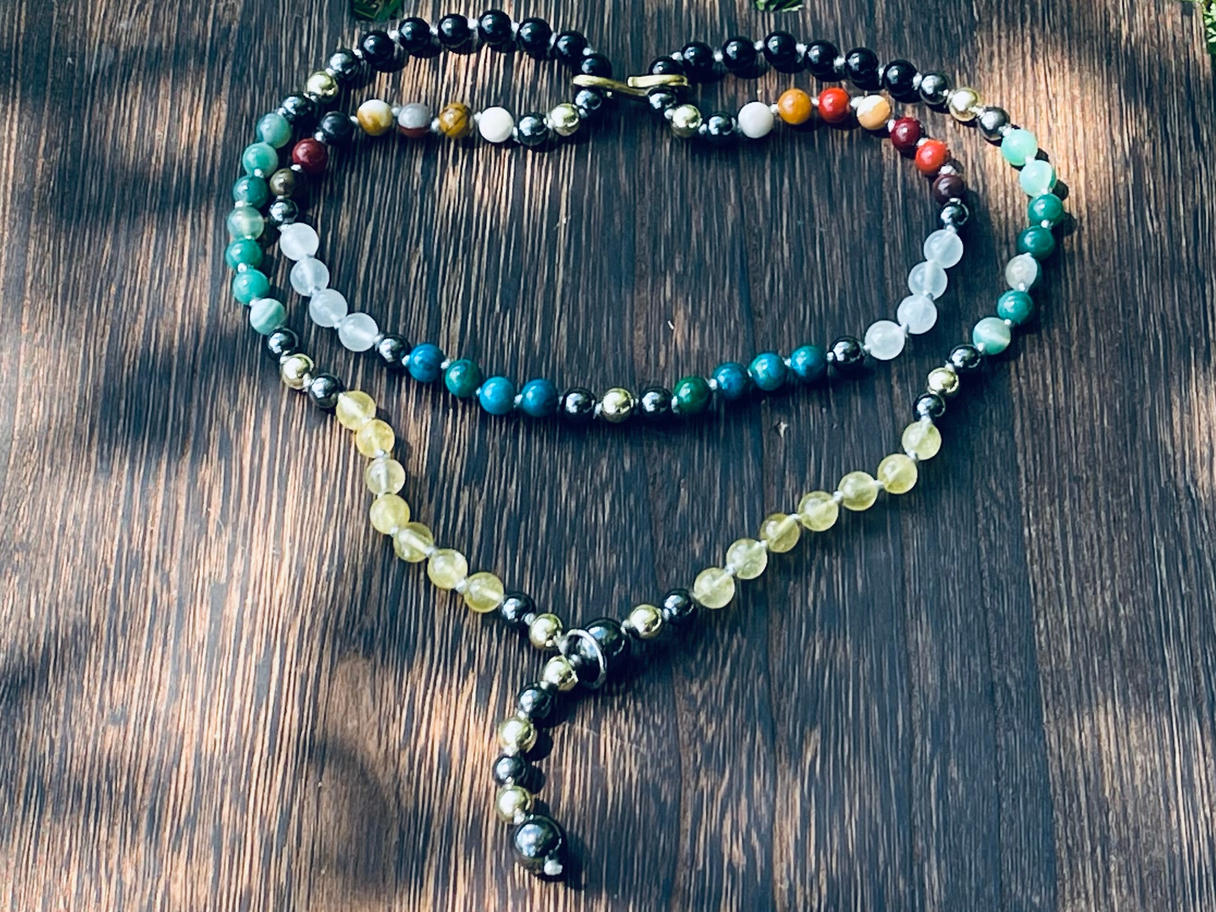 Handcrafted bespoke crystal mala by Starlight Rituals arranged in a heart shape, showcasing the natural gemstone design and individually hand-knotted craftsmanship.