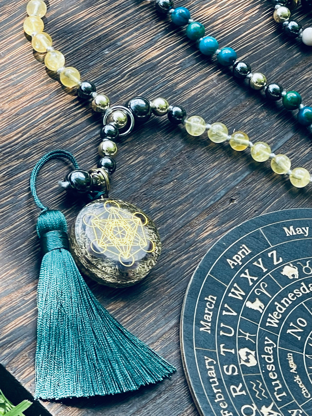 Close-up of a handcrafted bespoke crystal mala by Starlight Rituals, highlighting individually hand-knotted natural gemstones, the decorative focal pendant, premium rayon tassel and signature silver-toned soul cord.