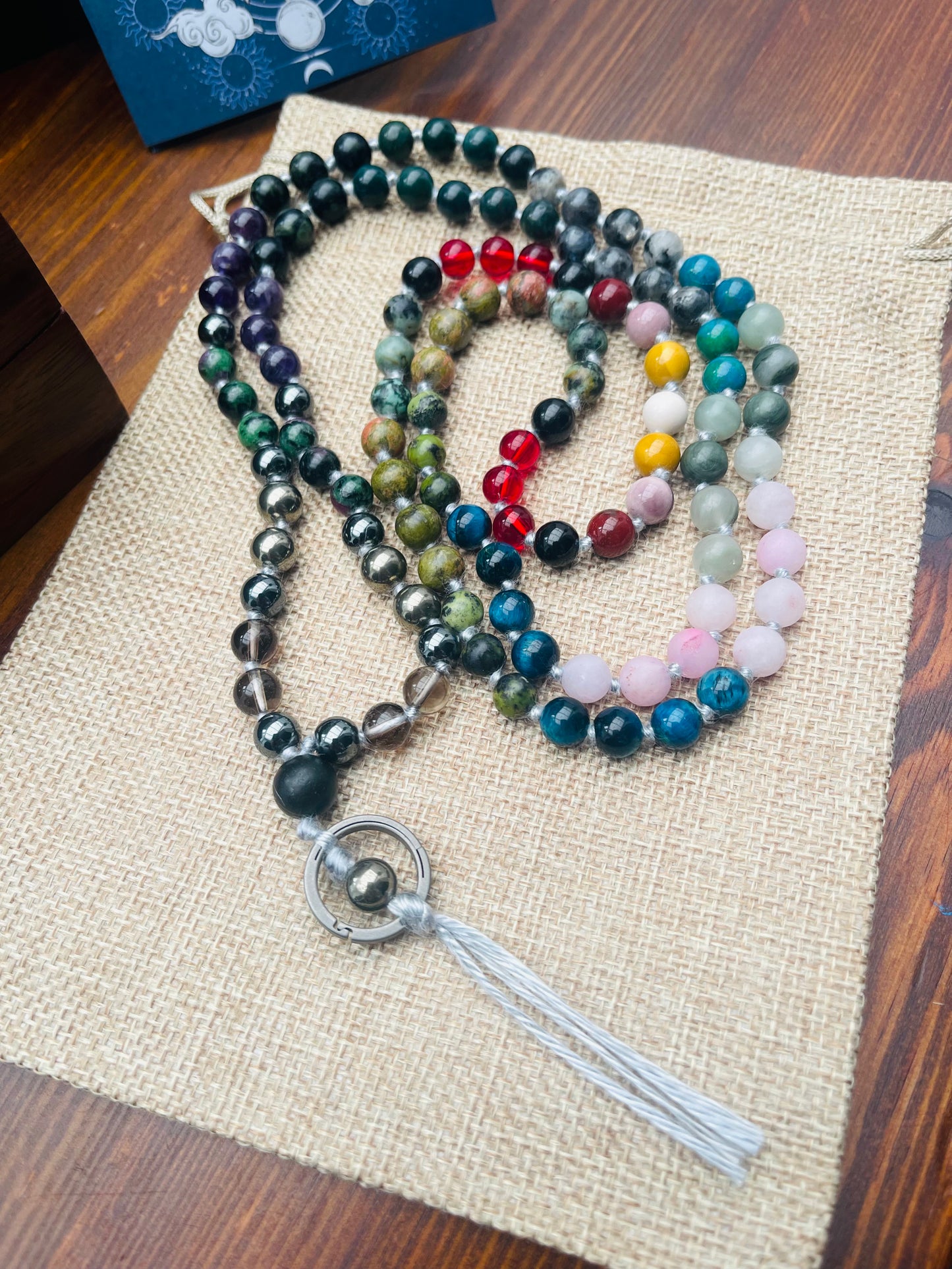 Handmade crystal mala beads laid on natural fabric showing bead detail and craftsmanship