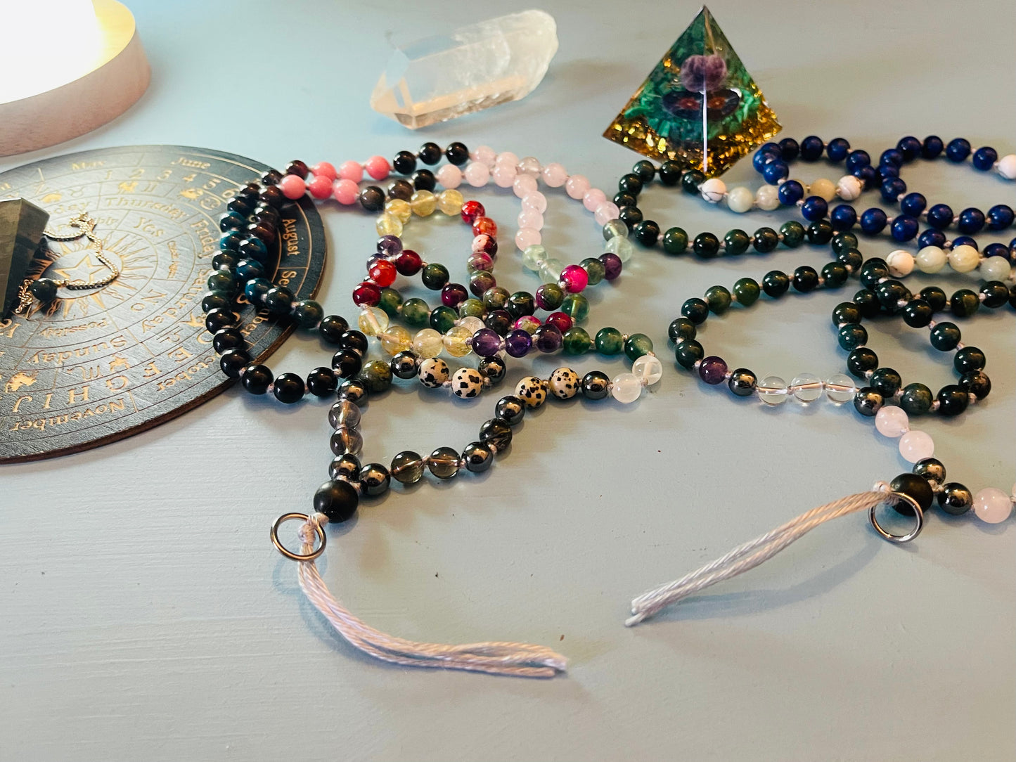 Crystal mala beads arranged with crystal lamp and spiritual tools creating a calming ritual scene