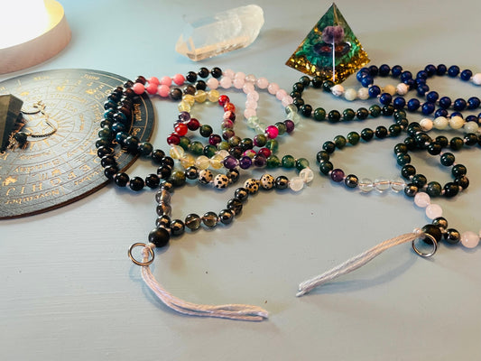 Crystal mala beads arranged with crystal lamp and spiritual tools creating a calming ritual scene